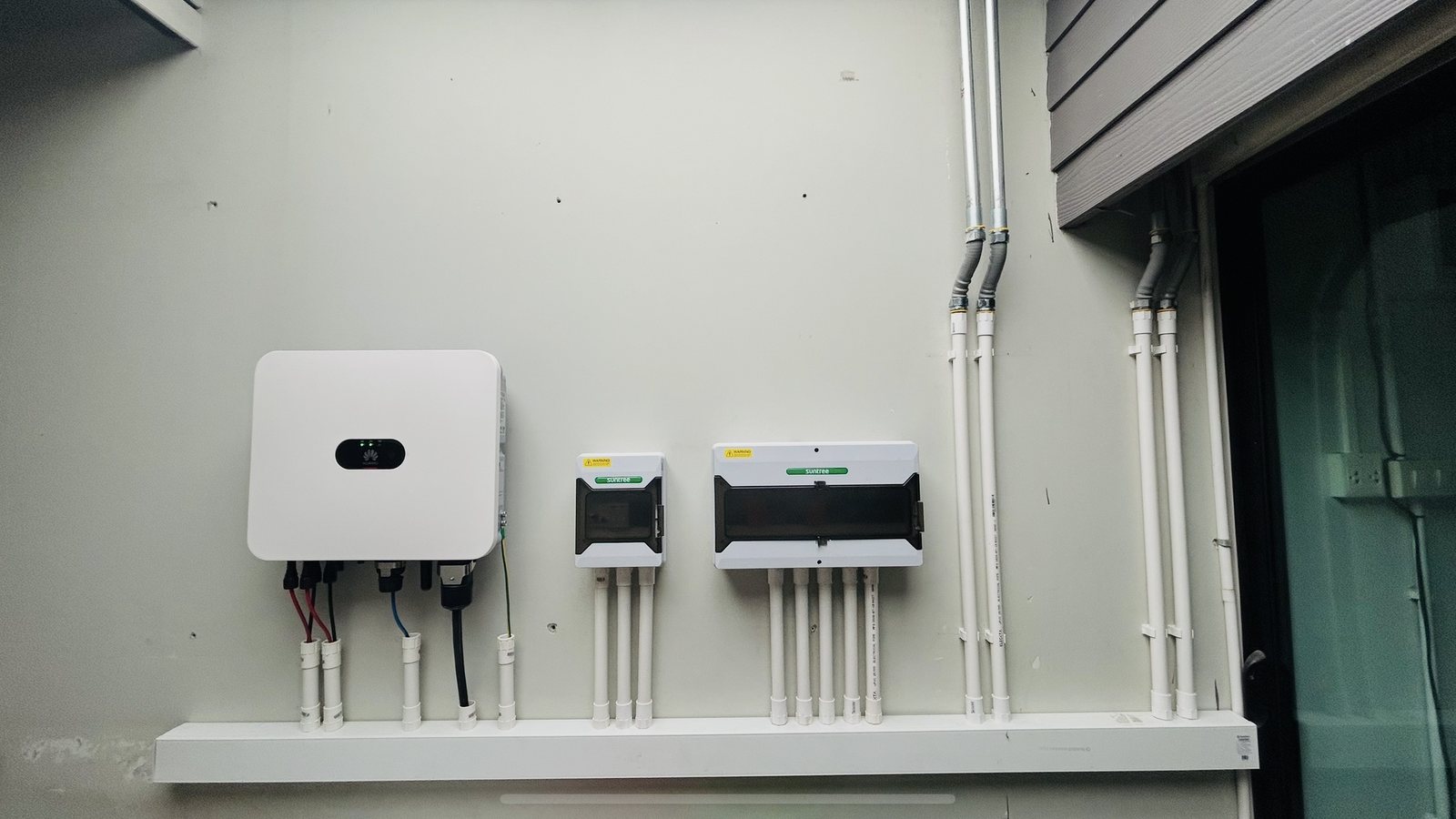 Grid-tie inverter and protection enclosures mounted on a wall