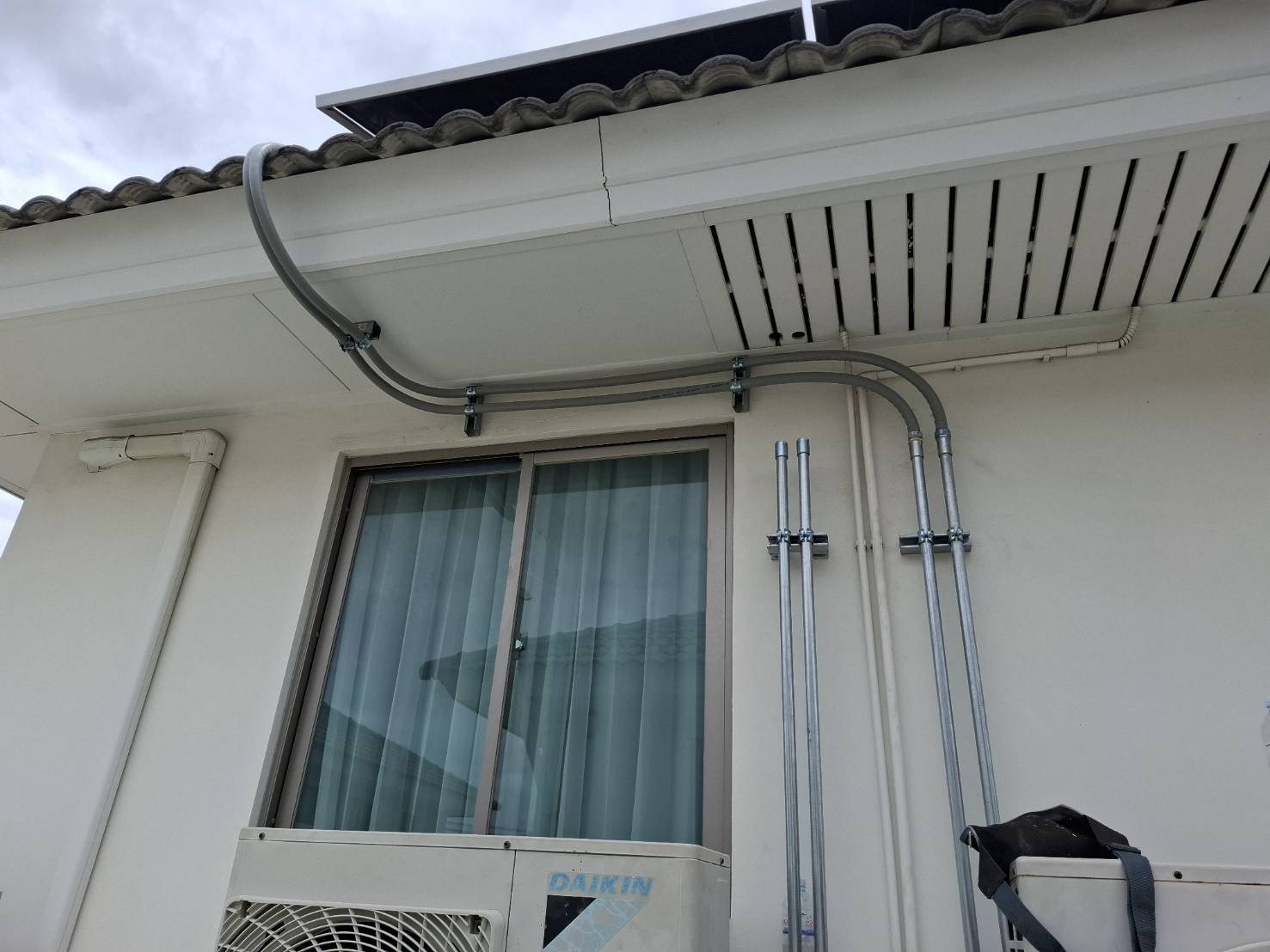 Cable conduit routed along a roofline and exterior wall